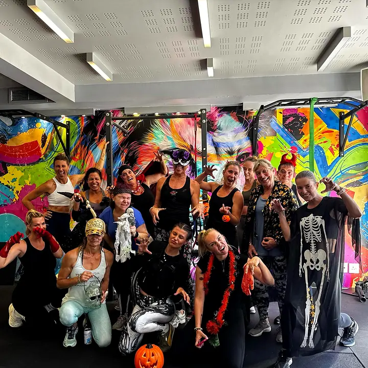 A costumed Halloween class group in front of the colourful Velocity graffiti mural