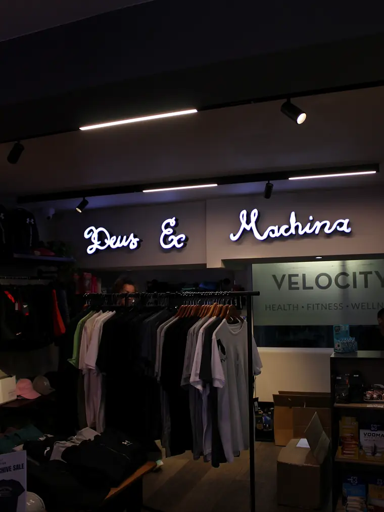 The Velocity Gear corner: Deus Ex Machina apparel under a neon sign