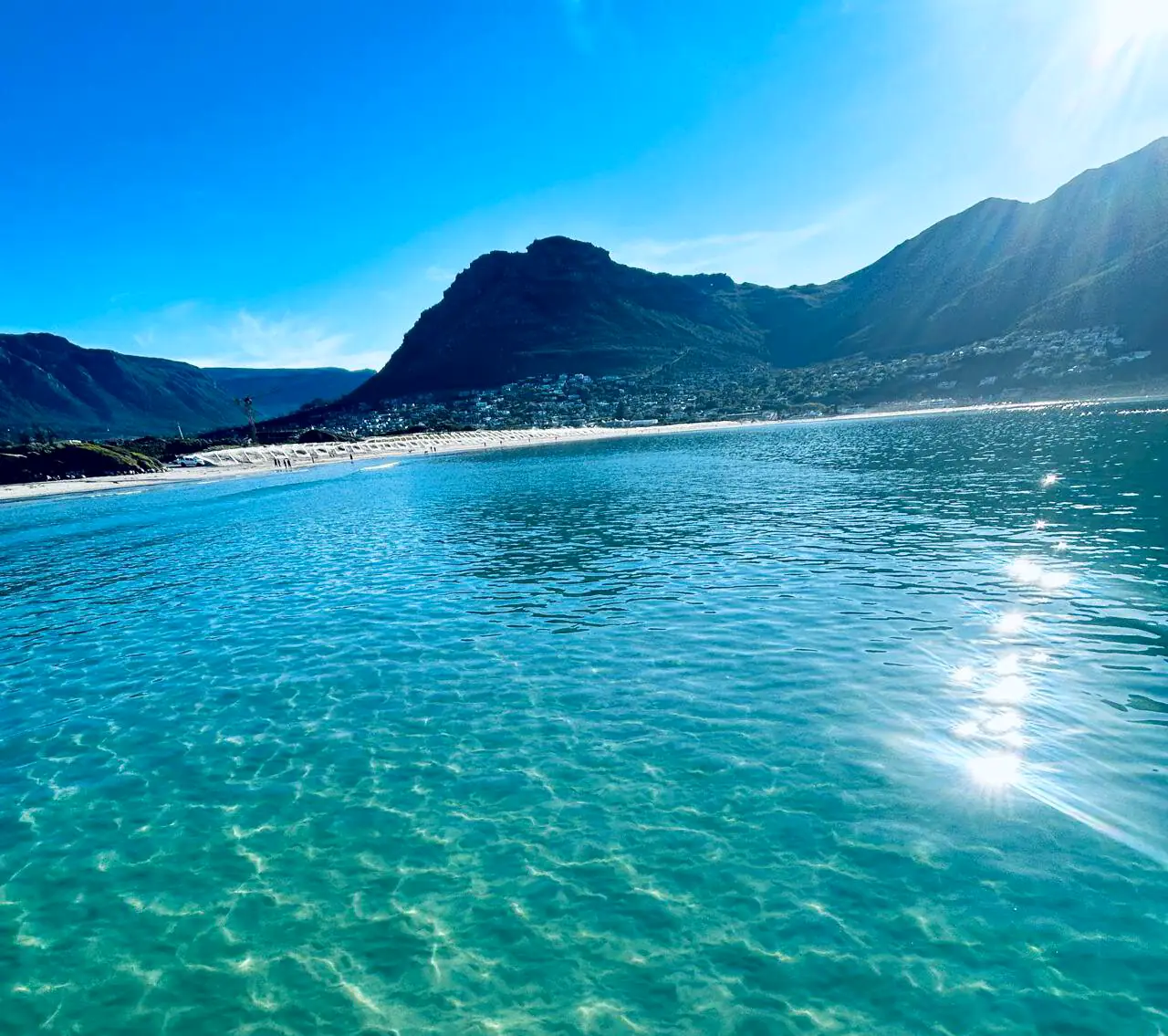 Clear turquoise water in Hout Bay with the mountains behind